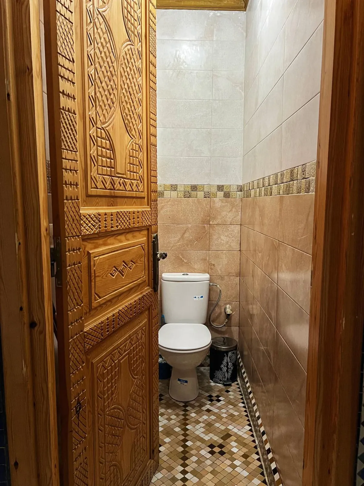 Les toilettes, porte en bois sculpté