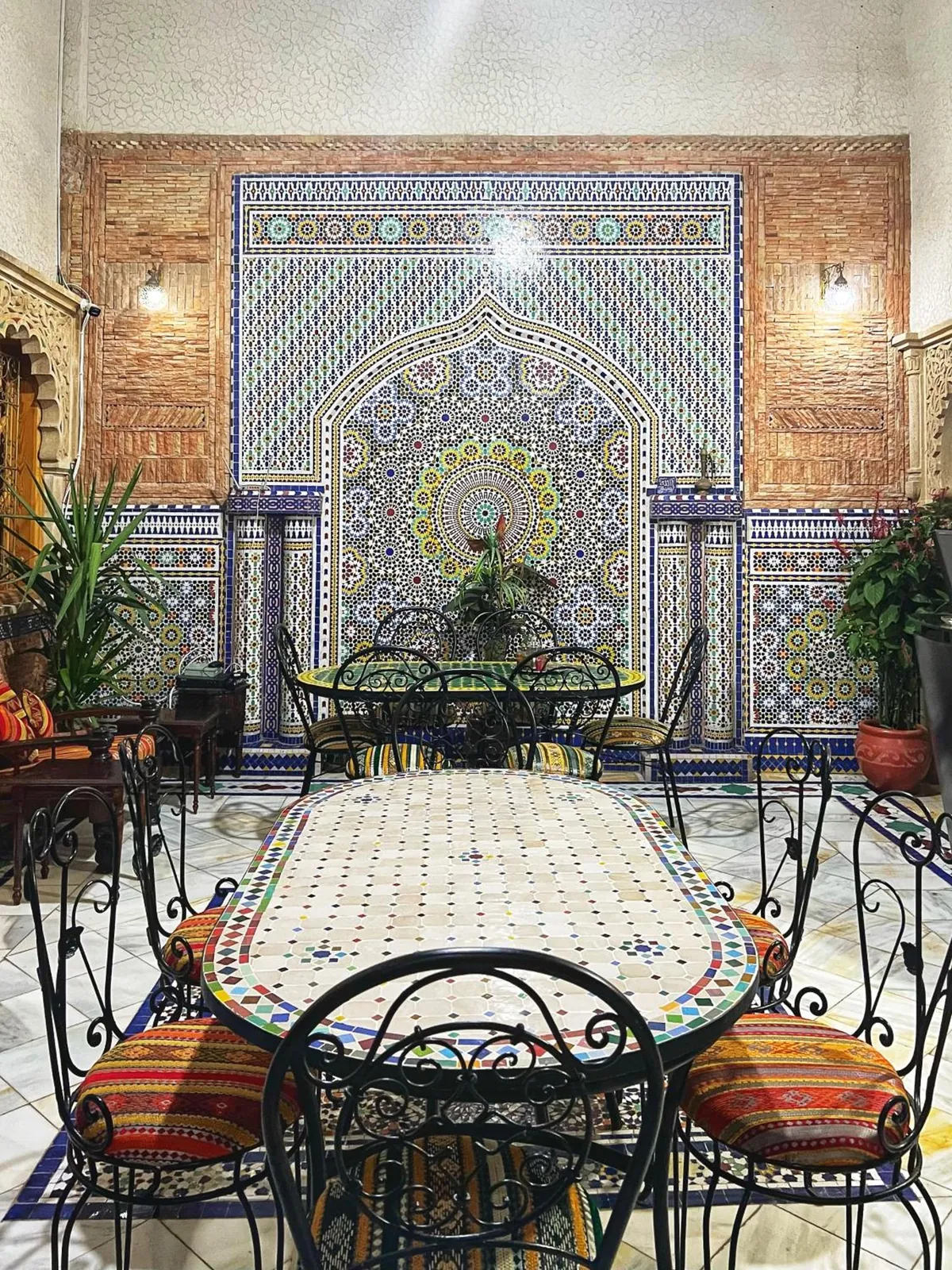 Le mur de la fontaine en zellige et la grande table