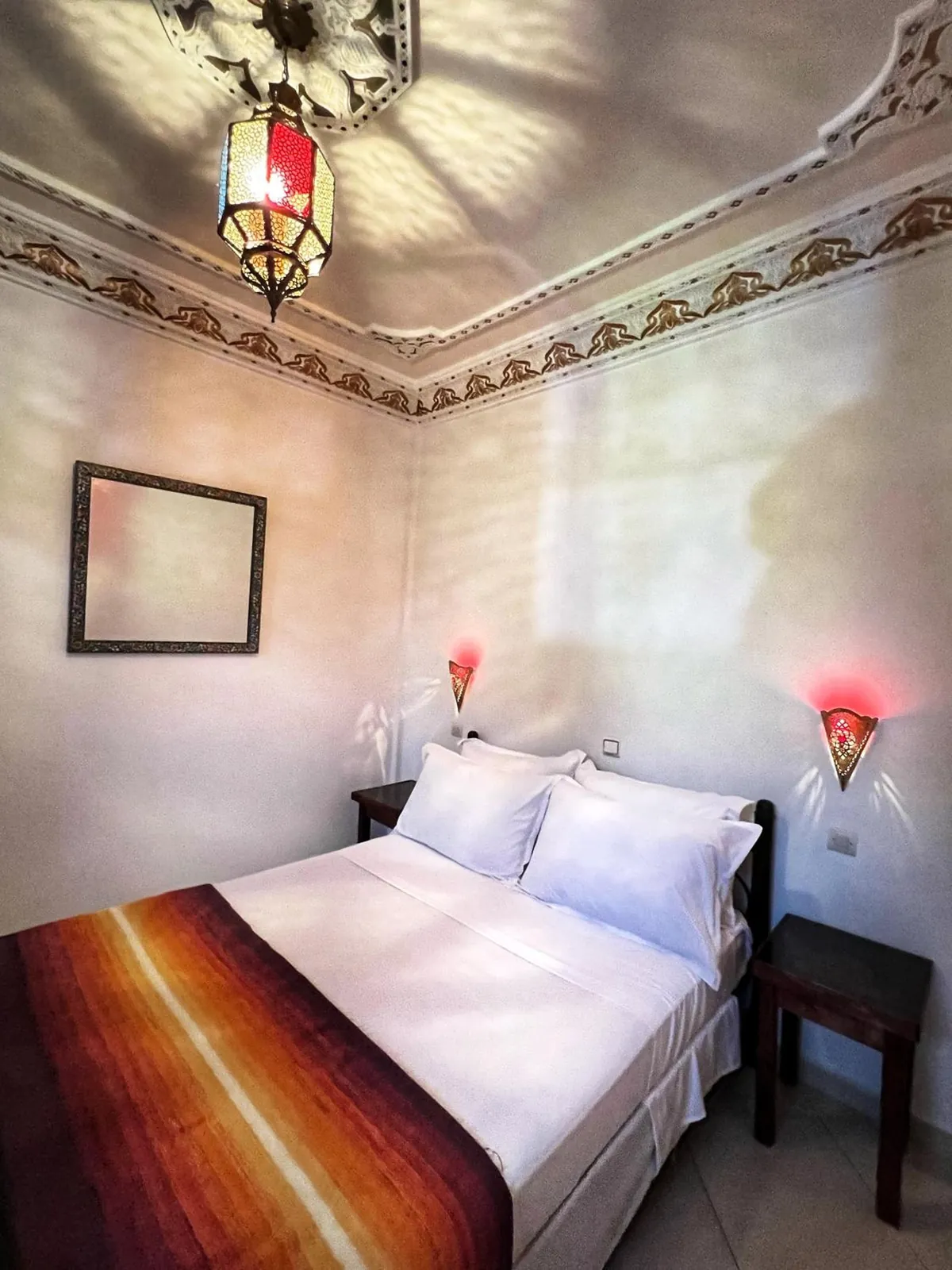 Double room, bed and coloured-glass lantern